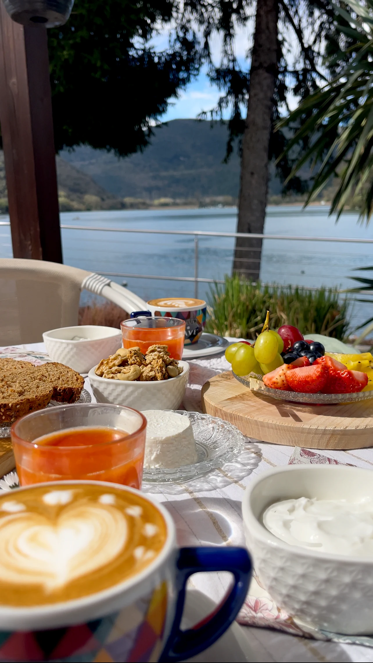 La colazione apparecchiata con cappuccino, frutta e yogurt davanti al Lago di Piediluco
